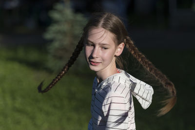 Girl in with braided hair spinning outdoors 