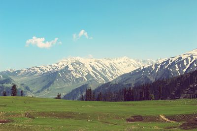 Scenic view of snowcapped mountains against blue sky