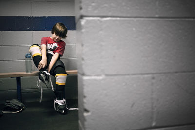 Boy putting on ice hockey skates