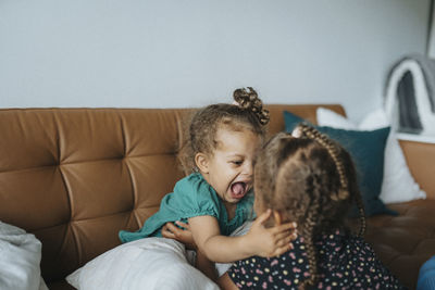 Sisters play-fighting at home