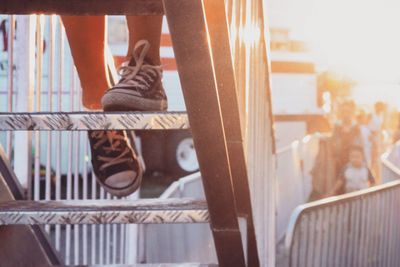 Low section of person walking on ladder