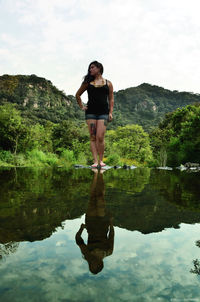 Full length of man standing in lake against sky