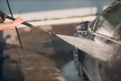 Cropped hand of person pouring water