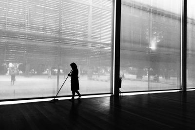 Woman cleaning passage of building