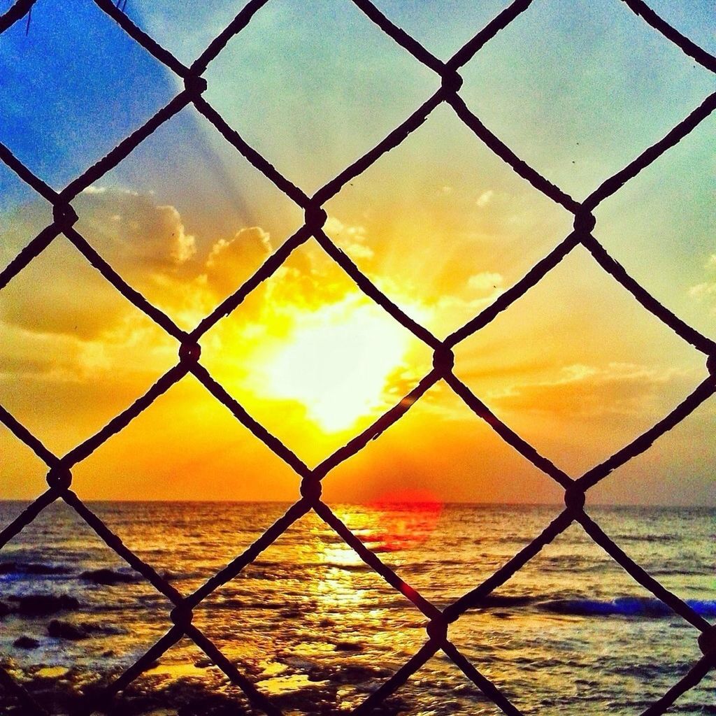 chainlink fence, sunset, protection, safety, fence, security, water, sea, orange color, sky, metal, backgrounds, full frame, scenics, beauty in nature, horizon over water, tranquility, nature, sun, focus on foreground