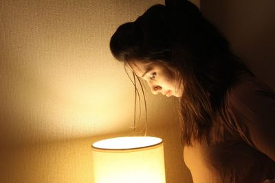Woman looking at illuminated lamp