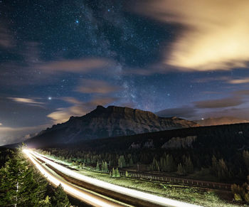Milky way over rundle mountain with highway light stream