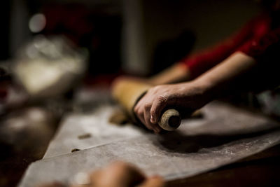 Cropped image of girl rolling dough in kitchen