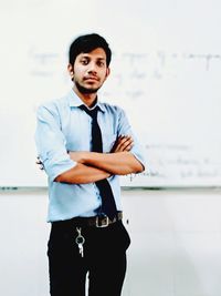 Portrait of young man standing at home