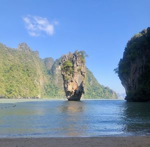 Scenic view of rocks by sea against sky