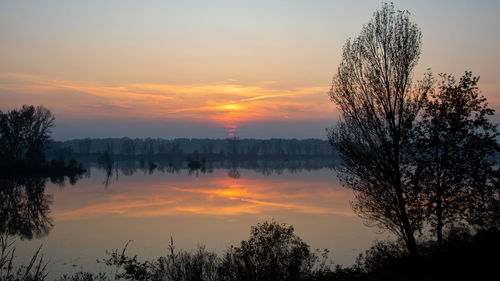 Scenic view of lake against romantic sky at sunset