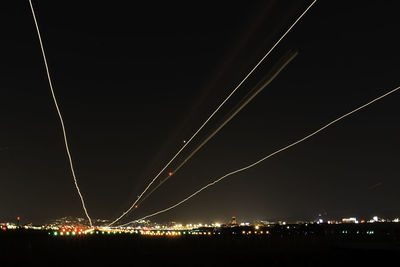 Low angle view of illuminated cityscape against sky at night