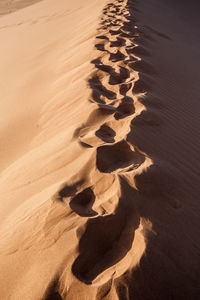 High angle view of footprints on sand