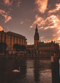 View of buildings and river against cloudy sky