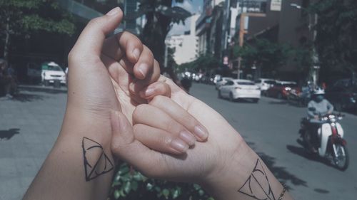 Cropped image of couple holding hands with tattoo