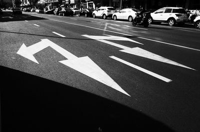 Arrow sign on road in city