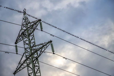 Low angle view of electricity pylon against sky