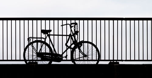 Silhouette bicycle parked against wall