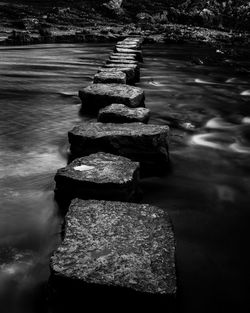 Stones in water against sky