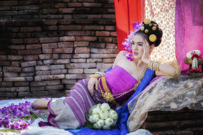 High angle view of woman sitting on stone wall