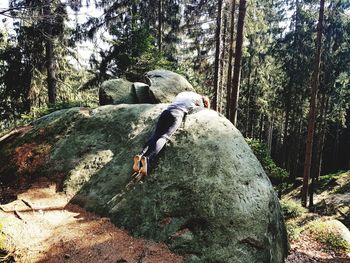 Man relaxing on rock in forest