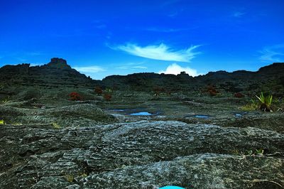 Scenic view of mountains against blue sky