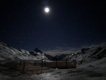 Scenic view of snow covered mountains against sky at night