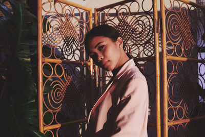 Young man looking away while standing on wall