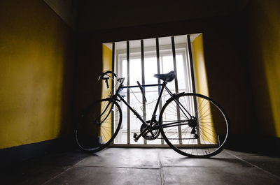 Bicycle parked by window in room