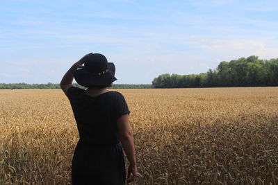 Man standing in wheat field against sky