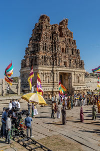 Camera operator with crew filming crowds outside temple at hampi