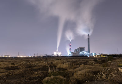 Smoke emitting from chimney against sky