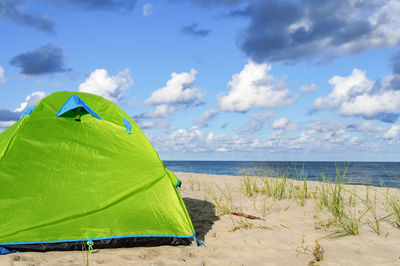 Green tent on the sea sand. hiking tent on the beach. baltic coast quiet sea.