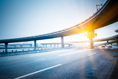 Bridge over road against sky in city