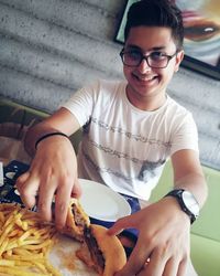 Portrait of smiling young man sitting at table