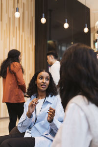Young female entrepreneur discussing business strategy with delegate at convention center