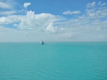 Boat sailing in sea against blue sky