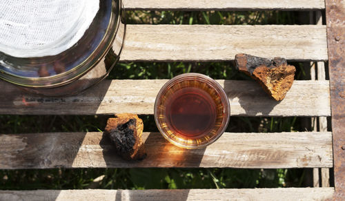 Natural chaga mushroom tea in a glass jar with pieces of natural birch mushroom. top view.