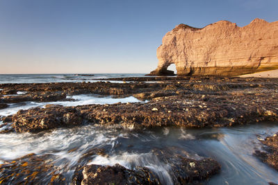 View of rocky beach against clear sky