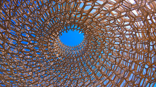 Low angle view of metal structure against blue sky