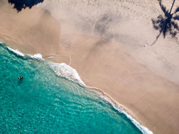 High angle view of white sand beach and turqoise sea