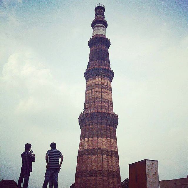 low angle view, architecture, sky, built structure, famous place, tower, international landmark, tourism, building exterior, lifestyles, travel destinations, tall - high, men, leisure activity, travel, capital cities, history, tourist