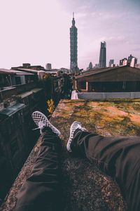 Low section of man standing on bridge in city