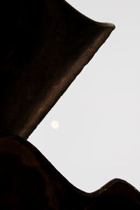 Low angle view of silhouette roof against clear sky