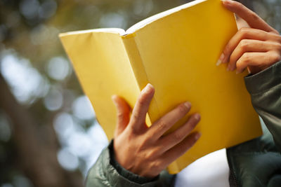 Midsection of woman holding yellow