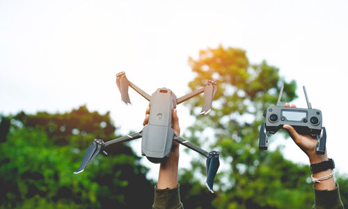 Low angle view of man photographing against sky