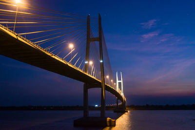 Low angle view of illuminated bridge against sky at night