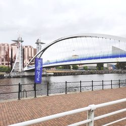 Bridge over river against buildings in city