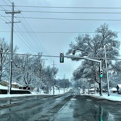 Road amidst trees against sky during winter