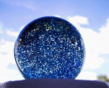 Close-up of bubbles on crystal ball against blue sky